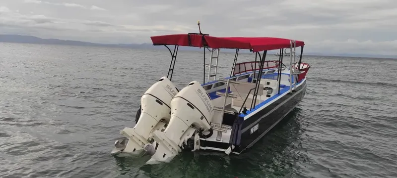Bateau de plongée à moteur sur l'eau calme sous ciel nuageux