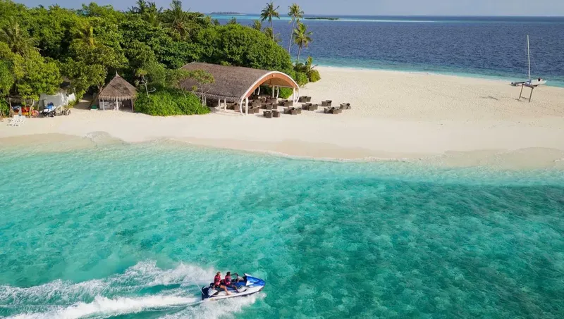 Vue aérienne d'une plage tropicale avec un bateau à moteur et des personnes