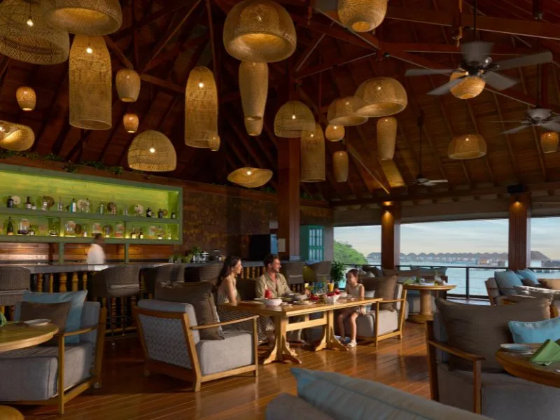Intérieur lumineux avec des fauteuils, un bar et une vue sur l'océan