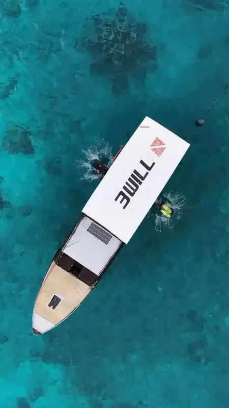 Vue aérienne d'un bateau de plongée avec des plongeurs dans l'eau turquoise