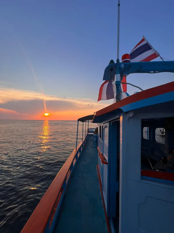 Bateau de plongée en mer au coucher du soleil, drapeau thaïlandais