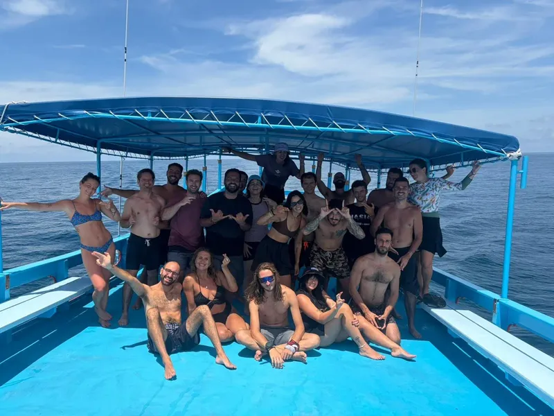 Groupe de personnes souriantes sur un bateau en mer, ambiance joyeuse