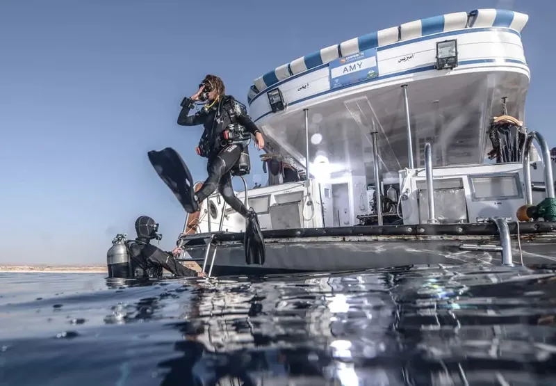Plongeurs s'apprêtent à entrer dans l'eau depuis un bateau de plongée