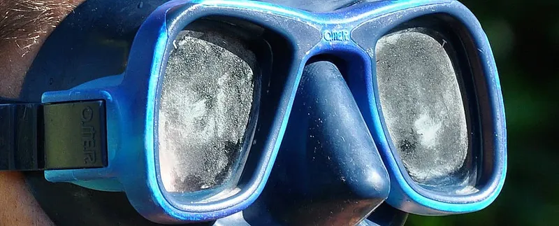 Masque de plongée bleu avec reflets, vue à travers les verres
