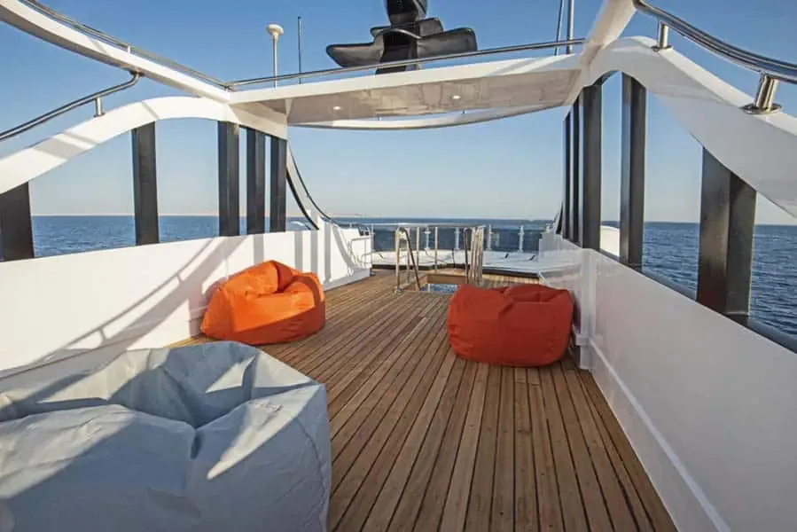 Terrasse en bois d'un bateau de plongée avec des fauteuils confortables