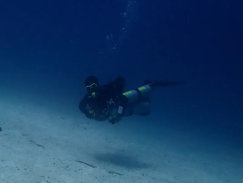 Plongeur en scaphandre explore les fonds marins dans une eau bleue