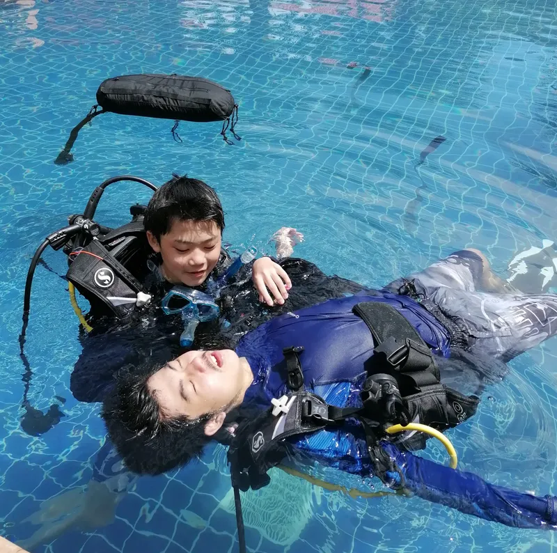 Deux plongeurs en formation flottent à la surface d'une piscine