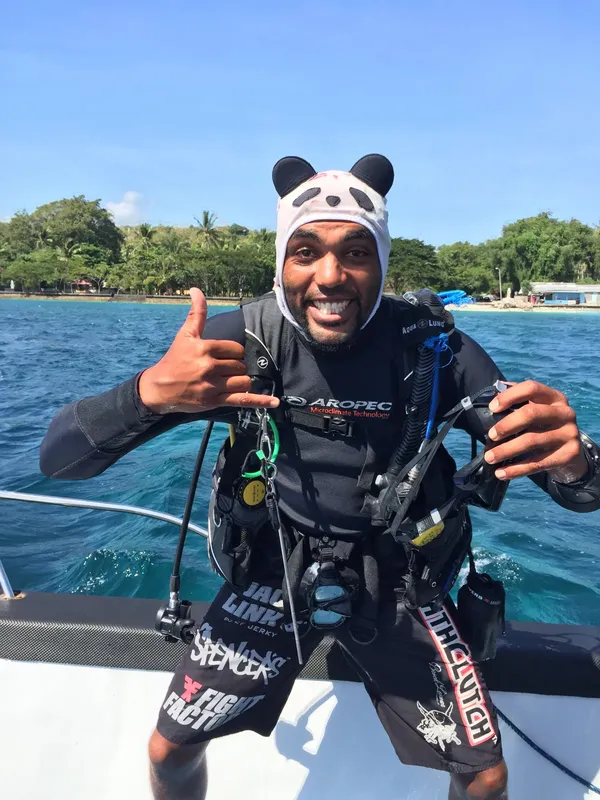 Plongeur souriant avec cagoule panda sur un bateau en mer