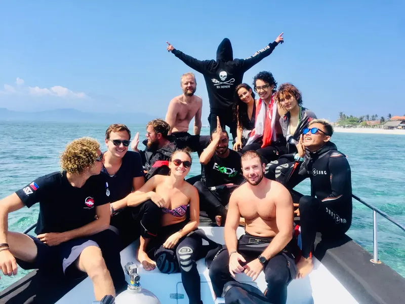 Groupe de personnes souriantes à bord d'un bateau en mer
