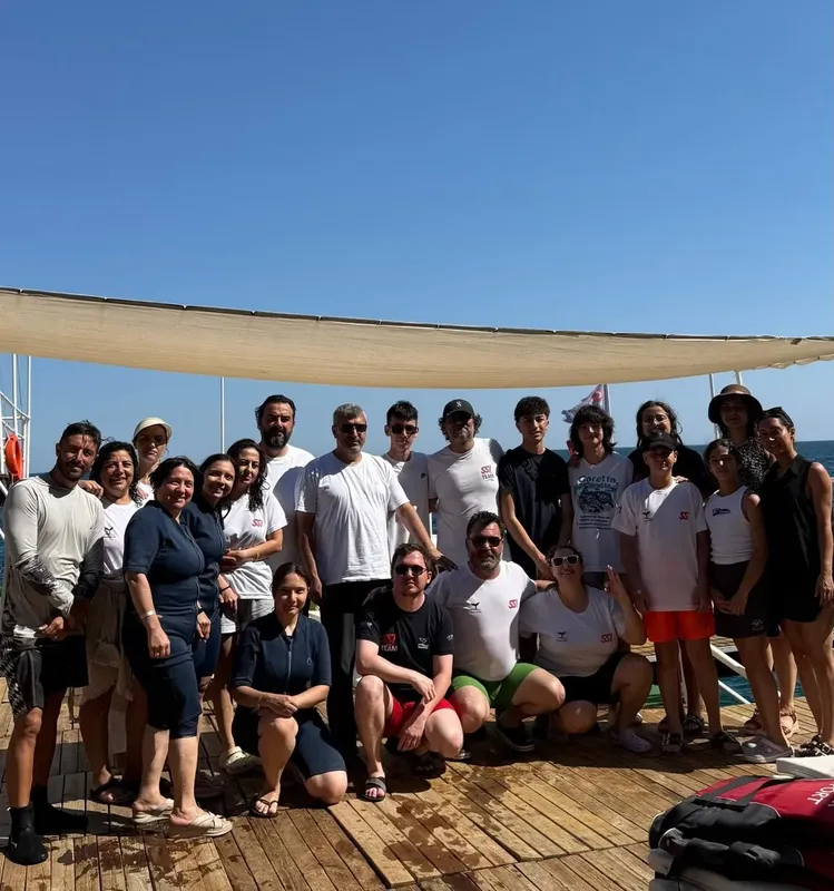 Groupe de personnes souriantes posant sur un ponton ensoleillé