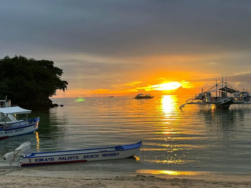 Plusieurs bateaux de pêche au coucher du soleil sur une mer calme