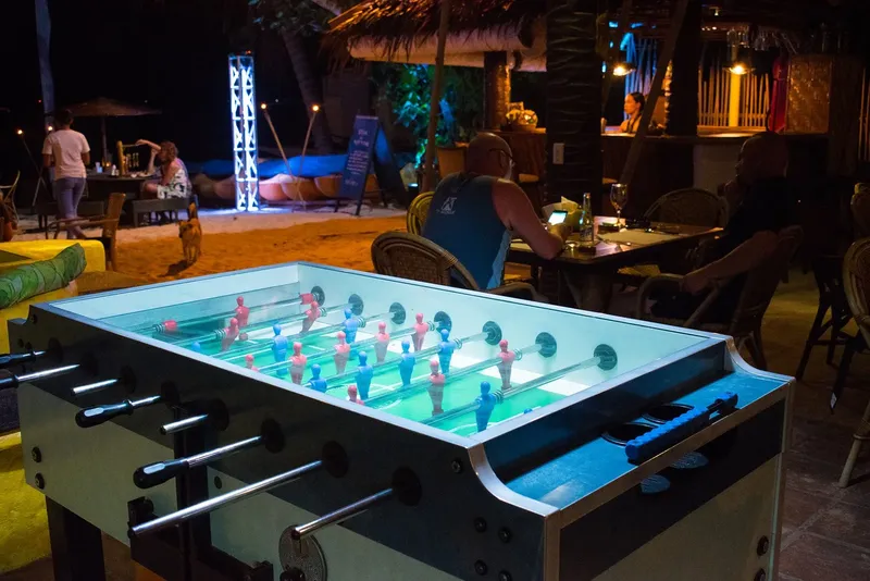 Terrasse de restaurant avec baby-foot et personnes assises en soirée