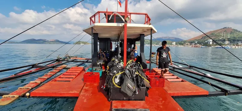 Bateau de plongée rouge avec équipement et un plongeur à bord