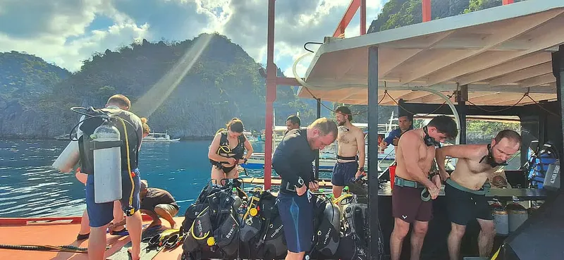 Plongeurs se préparant sur le bateau avec leur équipement complet