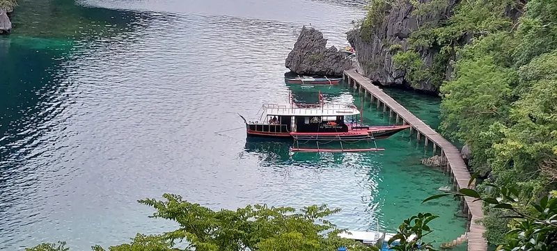Bateau de plongée amarré à un ponton dans une baie turquoise