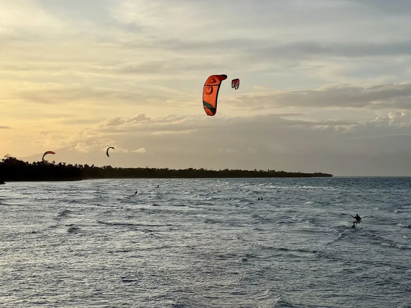 Kitesurfeurs sur l'océan au coucher du soleil, paysage marin paisible