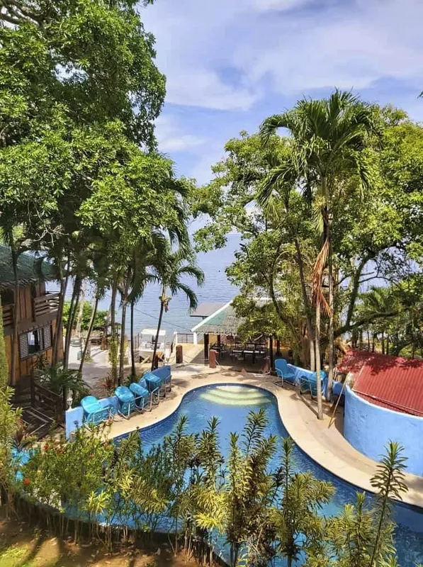 Vue d'ensemble d'un centre de plongée avec piscine et végétation tropicale