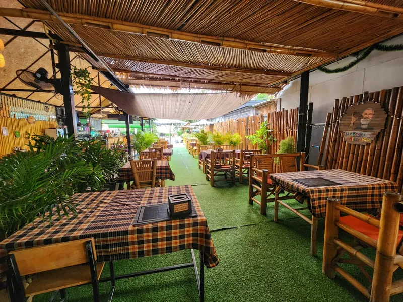 Terrasse ombragée avec tables et chaises, végétation et décoration