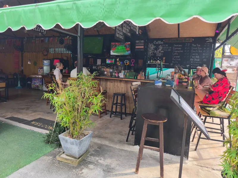 Bar extérieur avec clients assis, comptoir et menu visible