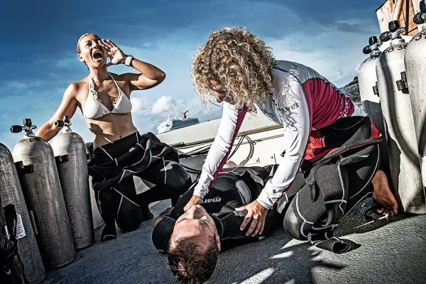 Secourisme : deux personnes soignent un plongeur inconscient sur un pont