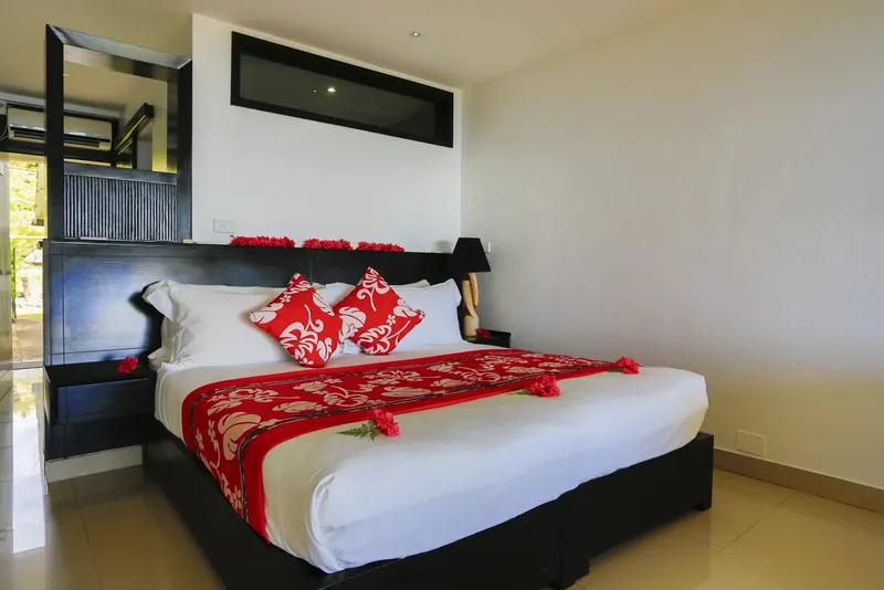 Chambre d'hôtel moderne avec un grand lit décoré de fleurs