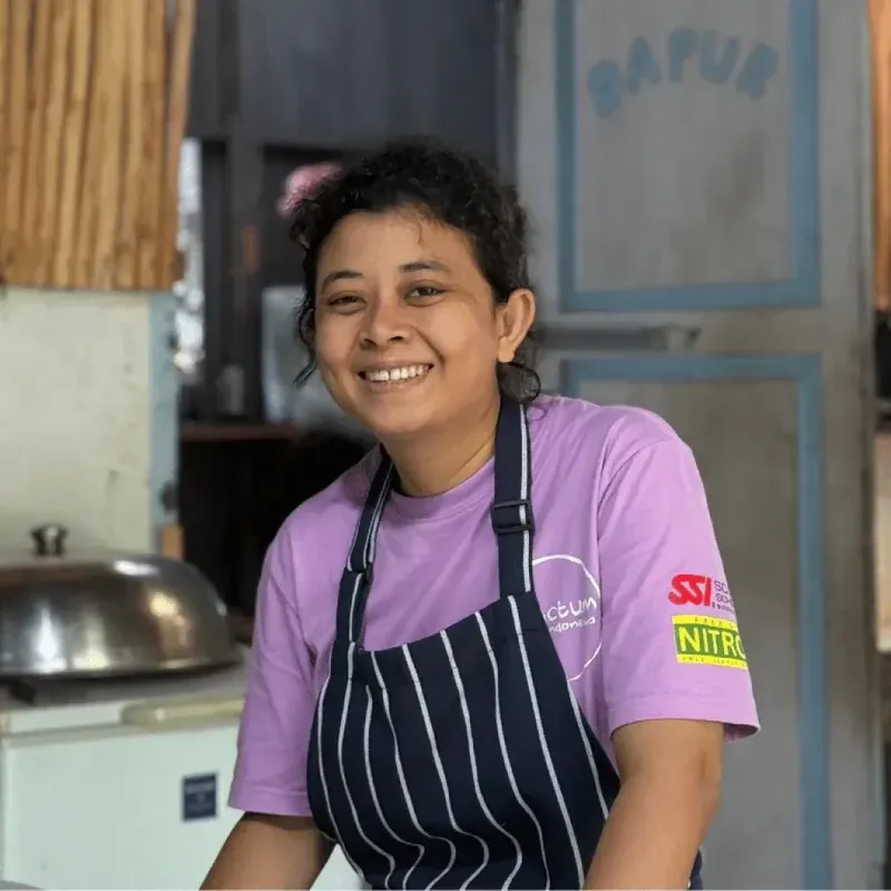 Femme souriante portant un tablier dans un intérieur coloré