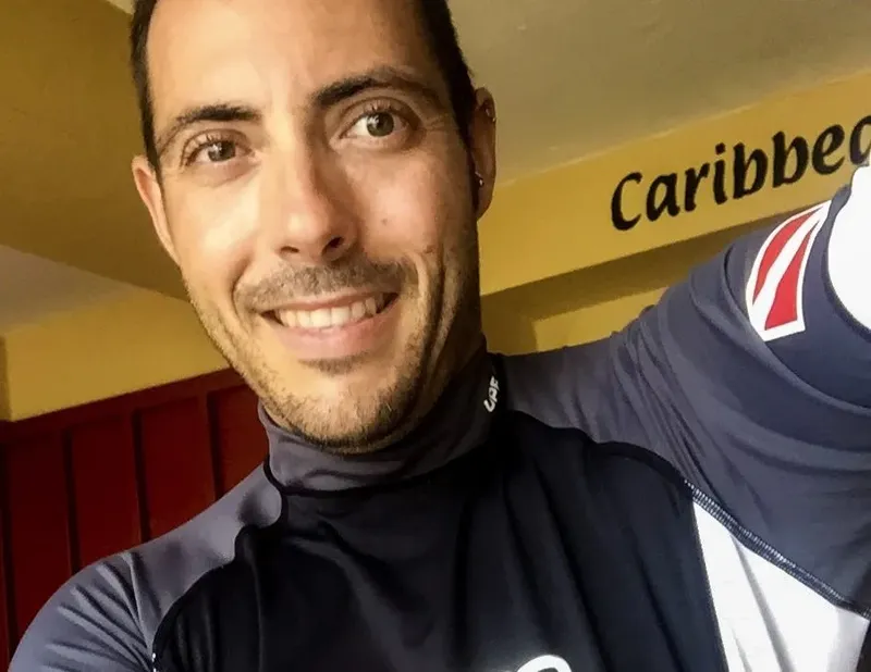 Portrait souriant d'un homme en combinaison de plongée devant un fond coloré