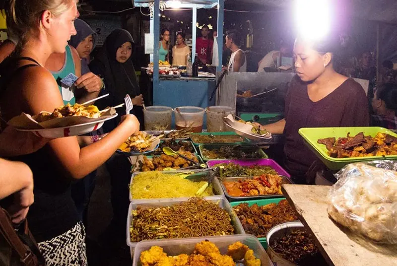 Personnes choisissent et achètent de la nourriture dans un marché nocturne animé