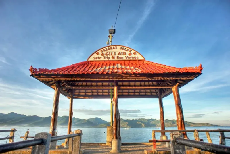 Kiosque en bois sur un ponton avec vue sur la mer et montagnes
