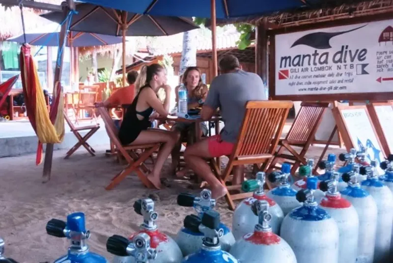 Plongeurs assis à table devant des bouteilles et un centre