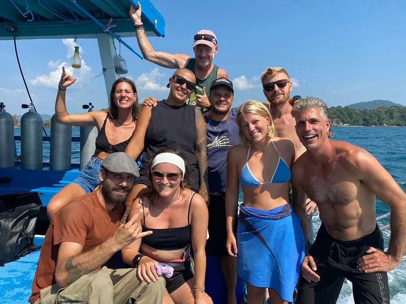 Groupe de personnes souriantes sur un bateau de plongée en mer