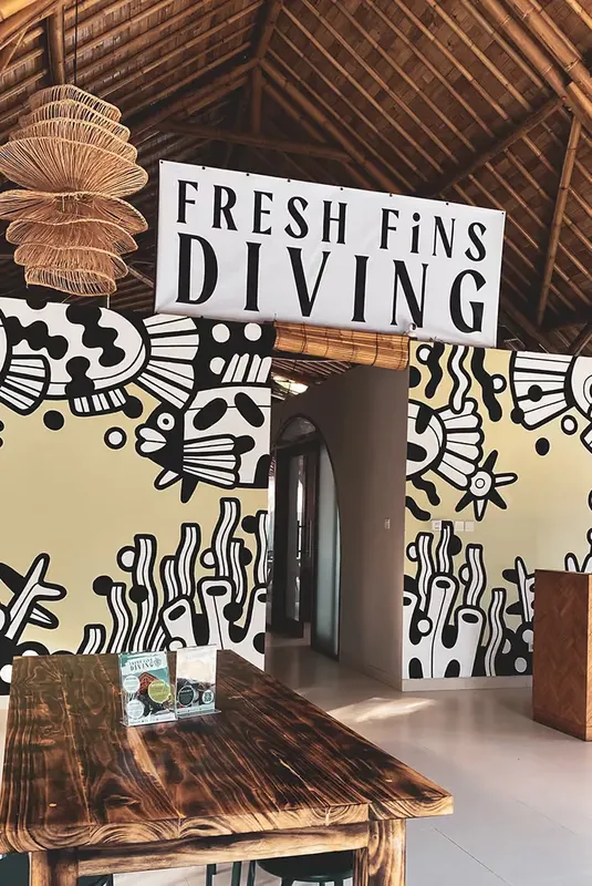 Entrée d'un centre de plongée décorée avec des motifs marins et du texte
