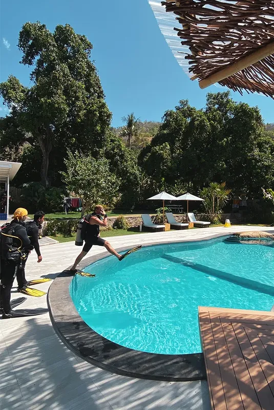 Personne s'apprête à entrer dans une piscine avec du matériel de plongée