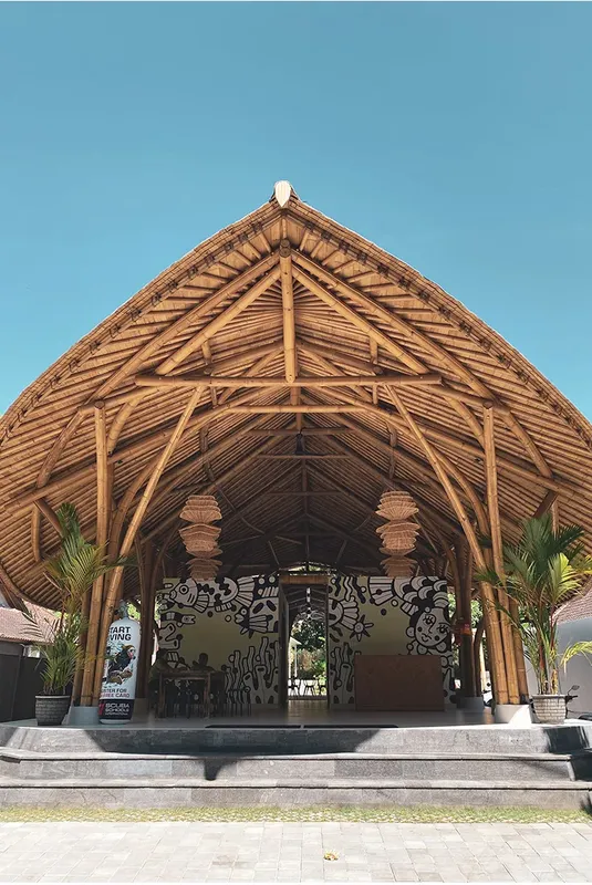 Architecture en bambou d'un bâtiment ouvert avec des palmiers et un ciel bleu