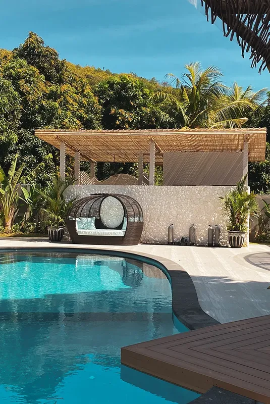 Piscine et espace détente avec pergola et végétation tropicale