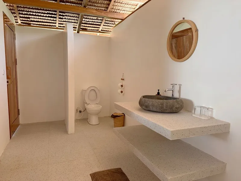 Salle de bain claire avec douche à l'italienne et lavabo en pierre