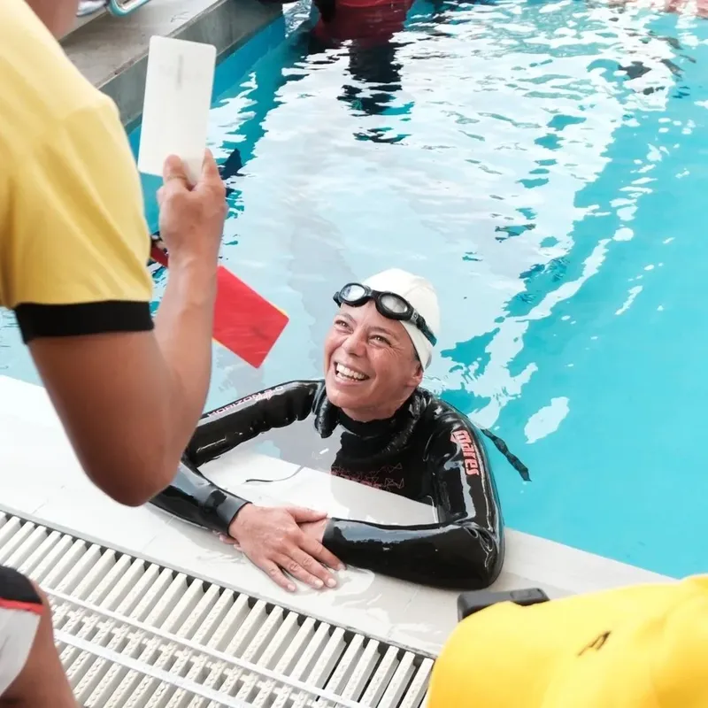 Plongeur souriant sortant d'une piscine avec un instructeur