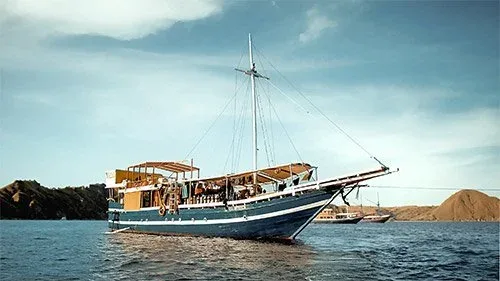 Bateau traditionnel en bois sur l'eau, paysage côtier en arrière-plan