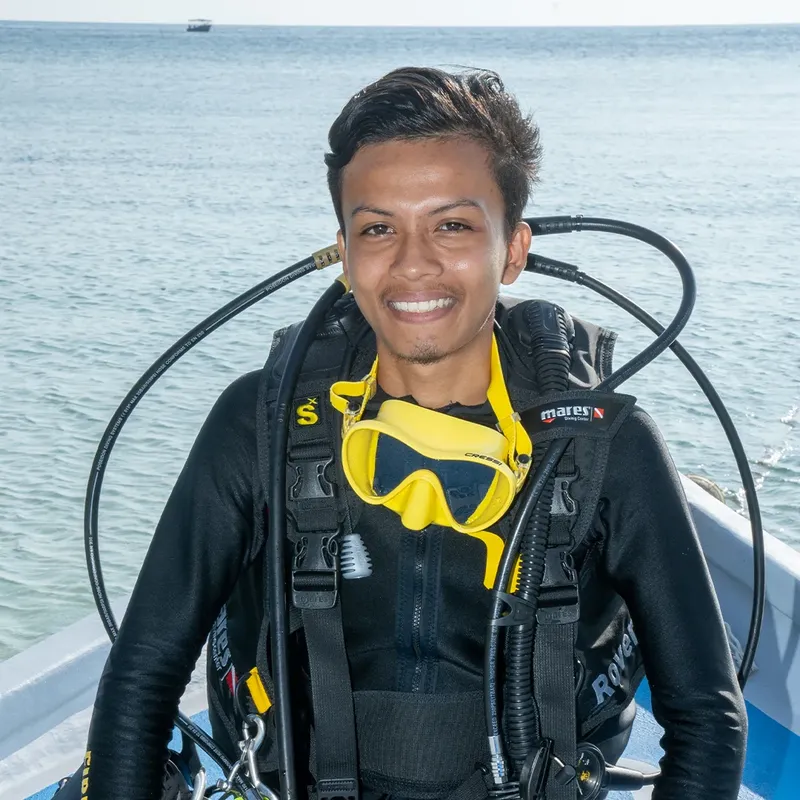 Plongeur souriant équipé d'un gilet et d'un masque jaune sur bateau