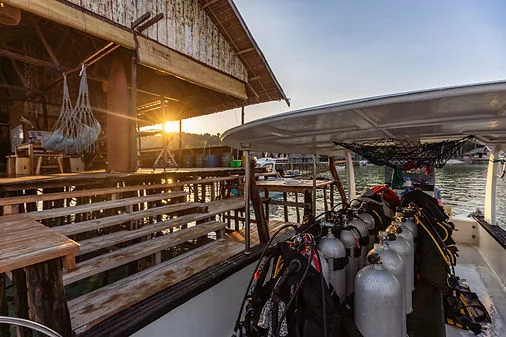 Bateau de plongée avec équipement, structure en bois et coucher de soleil