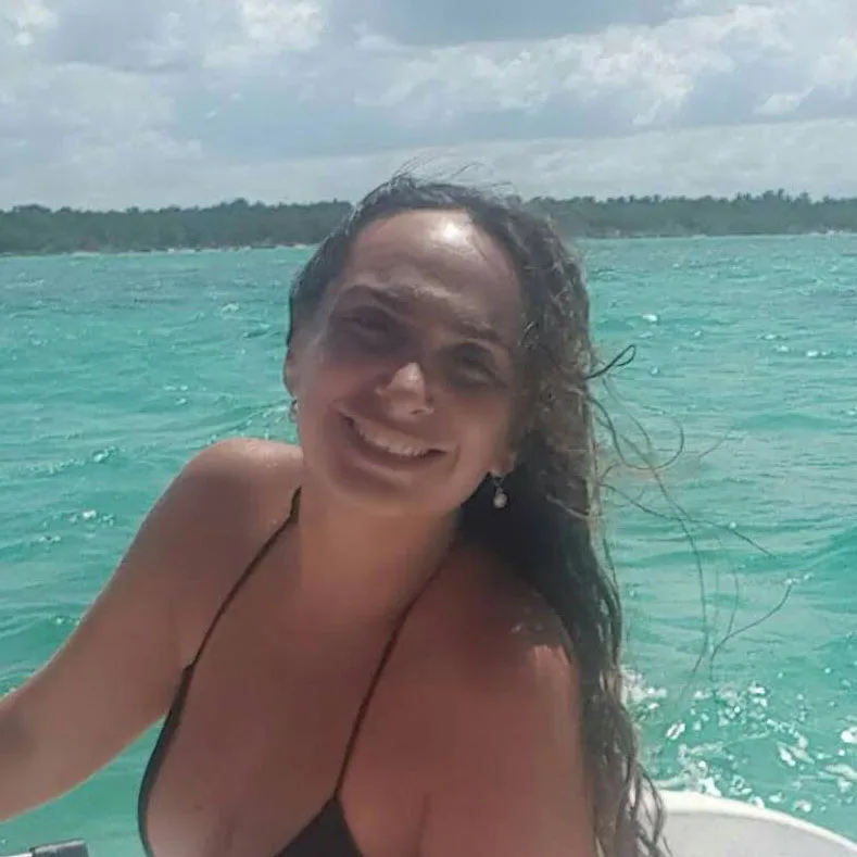 Jeune femme souriante sur un bateau en mer turquoise