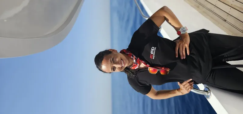 Homme souriant sur un bateau, portant un t-shirt avec un logo