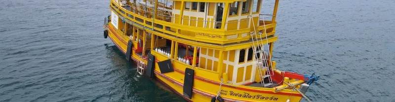 Grand bateau de plongée jaune à deux ponts sur l'océan calme