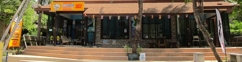 Façade d'un centre de plongée avec enseigne et matériel visible