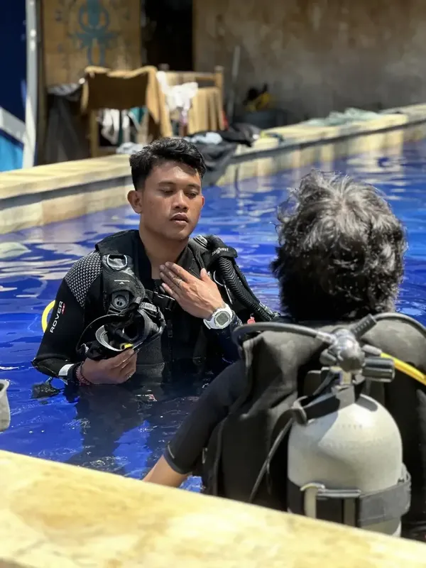 Deux plongeurs en formation, un instructeur vérifie l'équipement