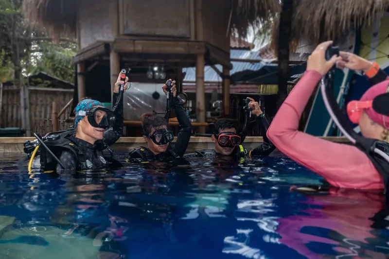 Plongeurs en formation dans une piscine, un instructeur prend des photos