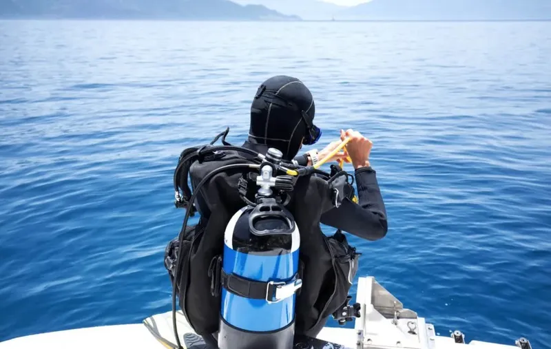 Plongeur préparant son équipement à bord d'un bateau en mer