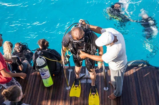 Préparation d'un plongeur sur le pont d'un bateau de plongée