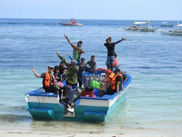Groupe de plongeurs joyeux sur un bateau bleu et blanc