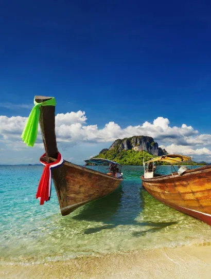 Long tail boats traditionnels amarrés sur une plage paradisiaque ensoleillée